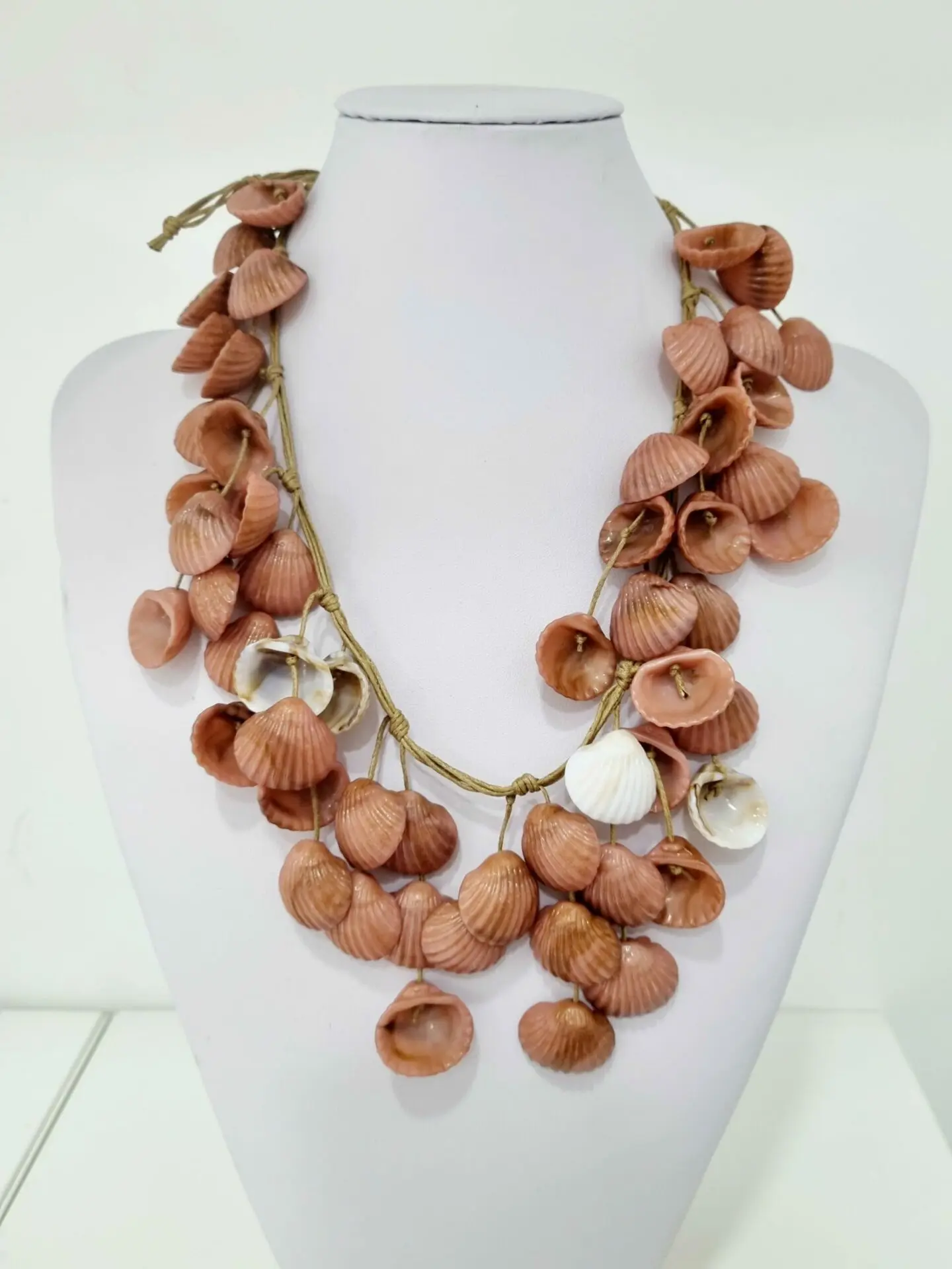 Necklace made with pink and white resin shells on cord. Button closure. Adjustable length 60 cm