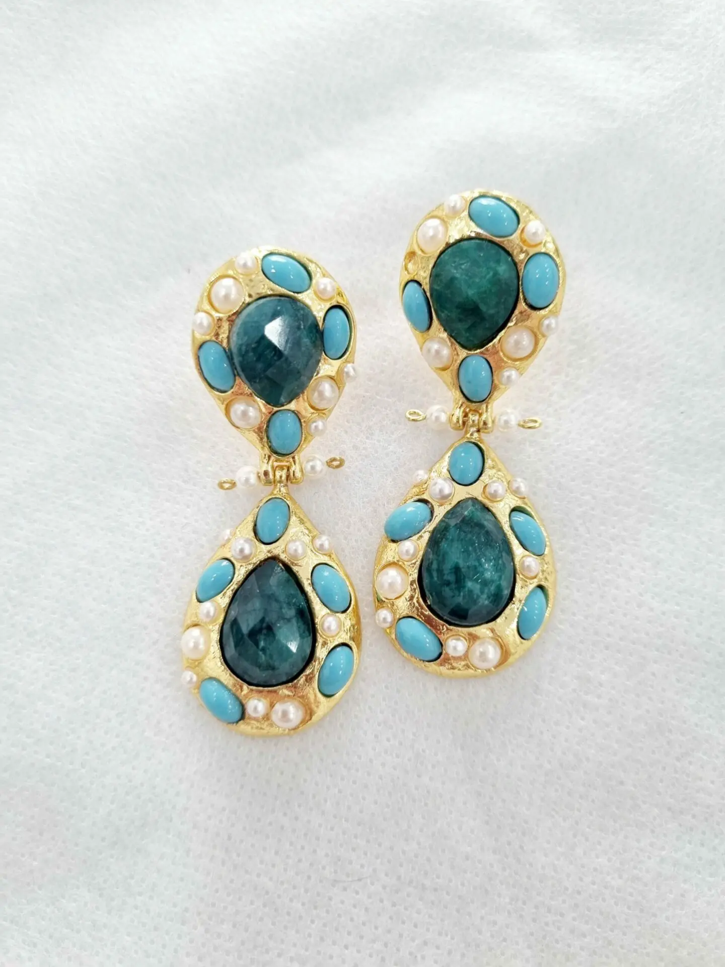 Boucles d'oreilles réalisées sur une base en laiton avec des pierres turquoises naturelles et des perles de Majorque serties Longueur 5cm Poids 12,3g.