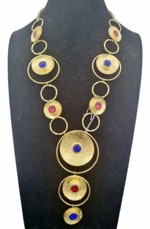 Collana realizzata artigianalmente con ottone martellato e cristalli blu e rossi.
Lunghezza girocollo 54cm pendente 11cm