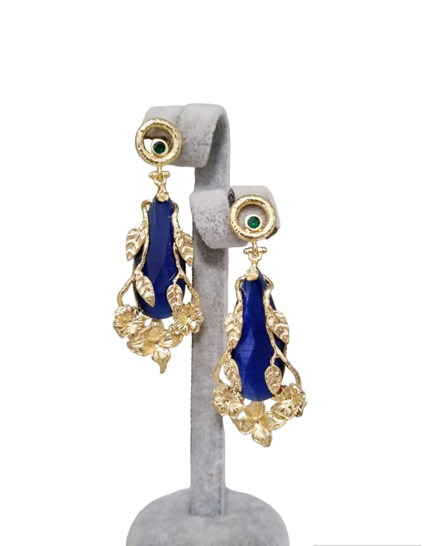 Earrings made with blue cat's eye surrounded by brass leaves. Brass pin with green zircon. Weight 11.1g Length 7cm