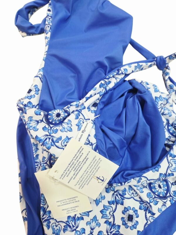 Costume intero double face, stampa blu capri ed unica tinta azzurra, bratelline regolabili con nodo, coppe interne.
Prodotto realizzato e disegnato esclusivamente in Italia. Spedizione Gratuita