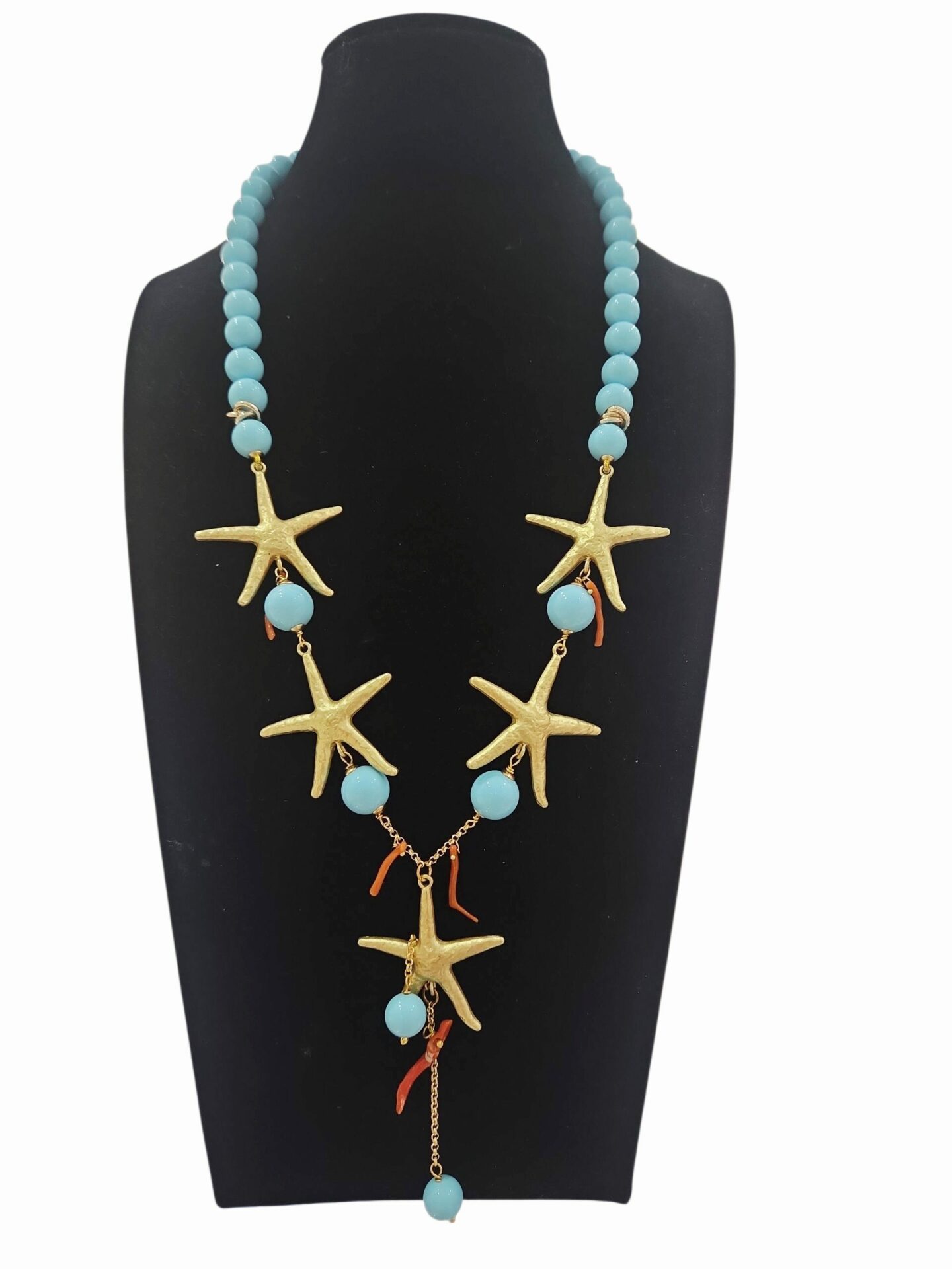 Collana realizzata artigianalmente con pasta di turchese, rametti di corallo e stelle in ottone dorate.lunghezza 59cmlunghezza ciondolo 9 cm Spedizione Gratuita