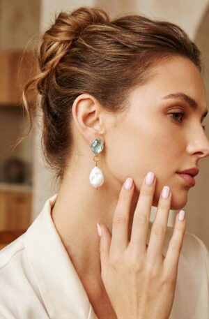 Orecchini realizzati con perla di fiume piatta e perno con  cristalloide acqua marina su base in ottone
lunghezza 5cm
peso 4.5gr Spedizione Gratuita