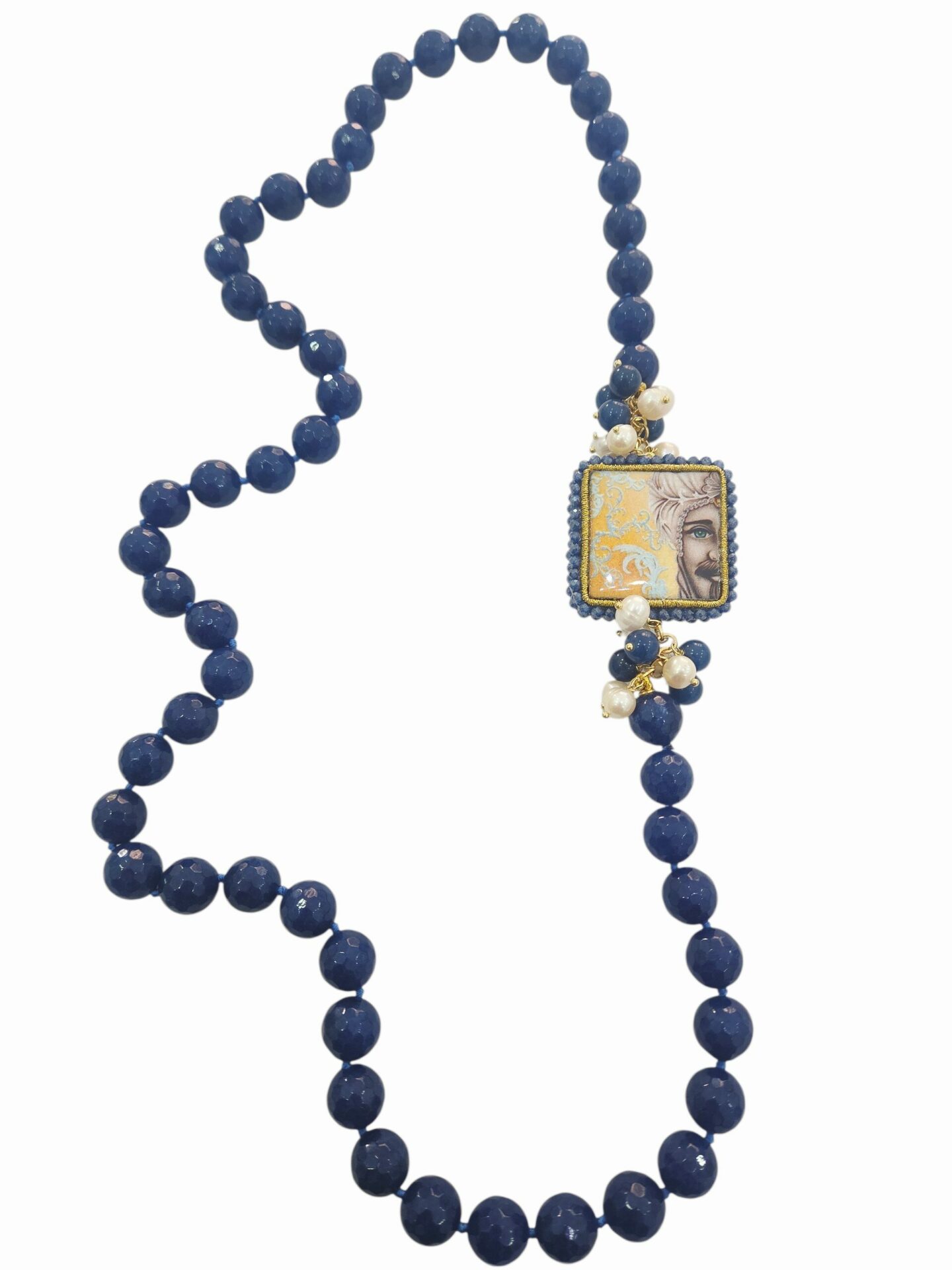 Collana lunga realizzata con agata blu,perle di fiume e laterale con ceramica di Caltagirone doppia in pietra lavica raffiguranti testa di moro uomo e donna contornati da quarzi
lunghezza 76cm Spedizione Gratuita