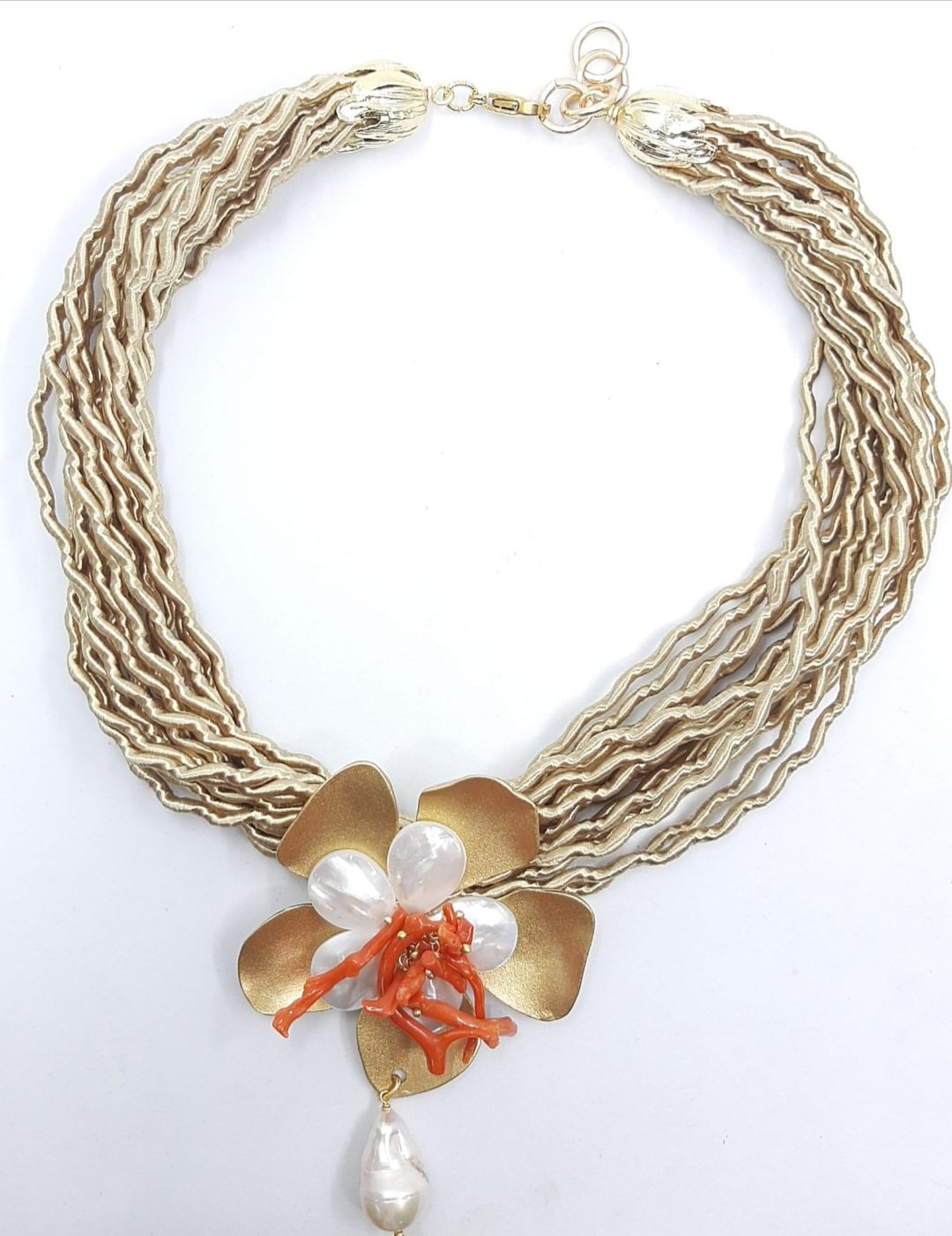 Collana girocollo realizzata artigianalmente con tessuto fiore in ottone e madreperla,corallo e perla scaramazza.
lunghezza 49cm Spedizione Gratuita