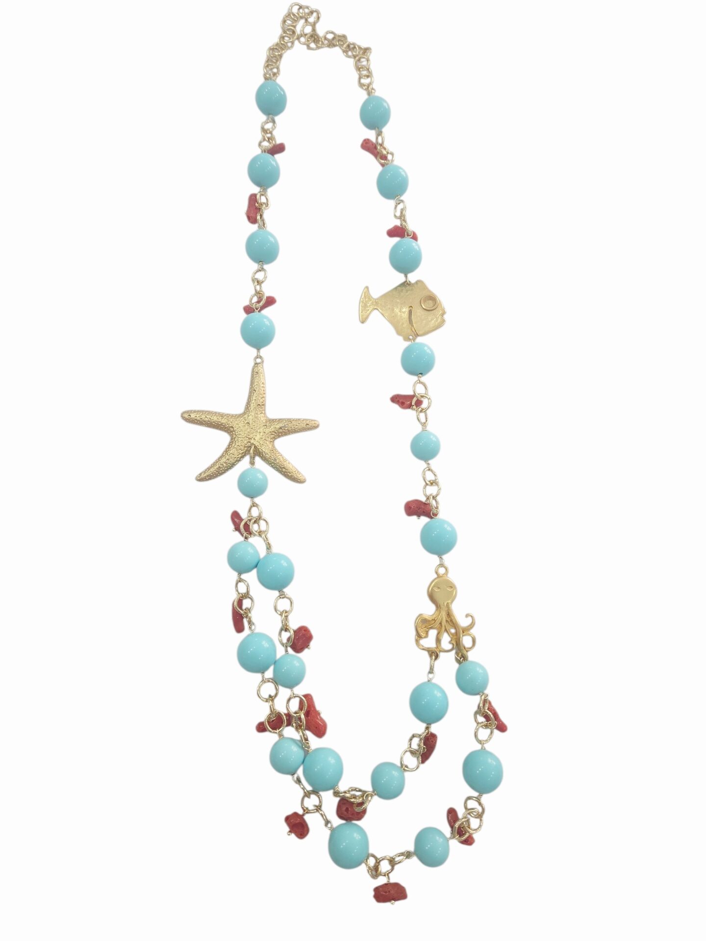 Collana lunga realizzata artigianalmente con sfere in pasta di turchese e corallo,elementi dorati marini in ottone. 
lunghezza 78cm Spedizione Gratuita
