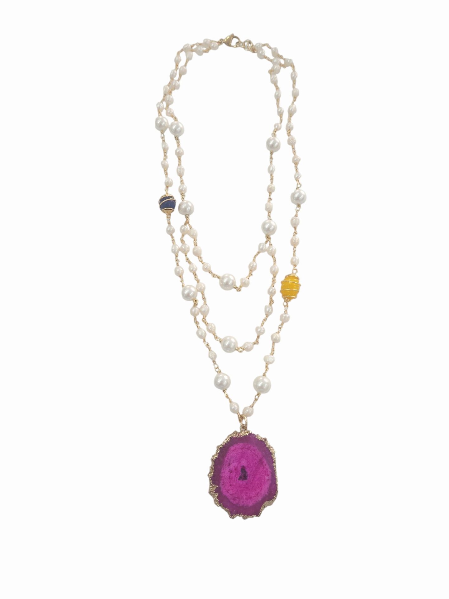 Collana realizzata artigianalmente con più fili di perle di fiume varie misure, agata blu e gialla e ciondolo in geode fucsia contornato da ottone. chiusura in acciaio.
lunghezza 45cm Spedizione Gratuita